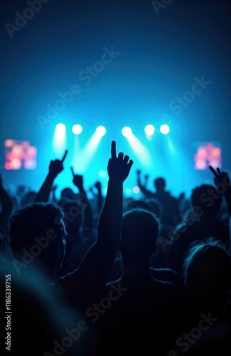 Energetic crowd enjoys live music performance. People raise hands under vibrant blue lights at night event. Great atmosphere. Concert venue filled with excitement, joy. Event strong feeling of