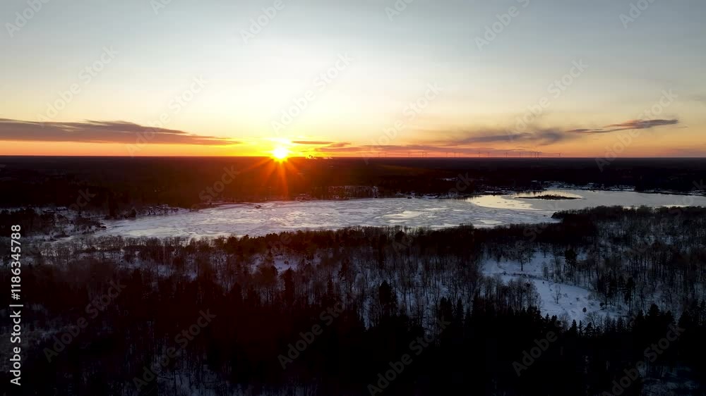 Frozen lake reflecting sunset light over winter forest Frozen lake reflecting sunset light over winter forest