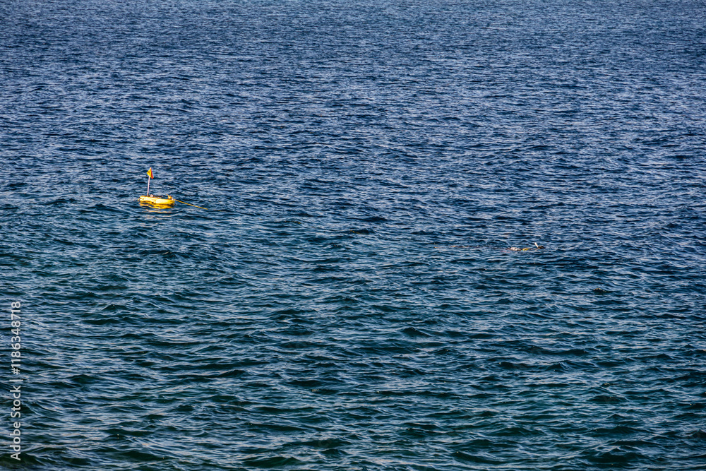 Diving in Mediterranean sea. Photo with a diver swimming under water with a diving tank next to it.