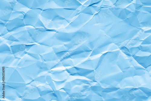 Creased or crumpled blue colored paper background. Wrinkled blank sheet texture