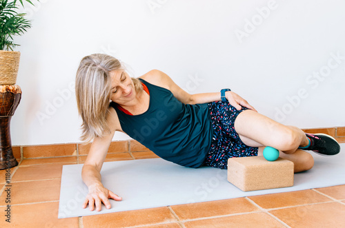 Athlete doing post-run recovery with therapy ball for muscle relief