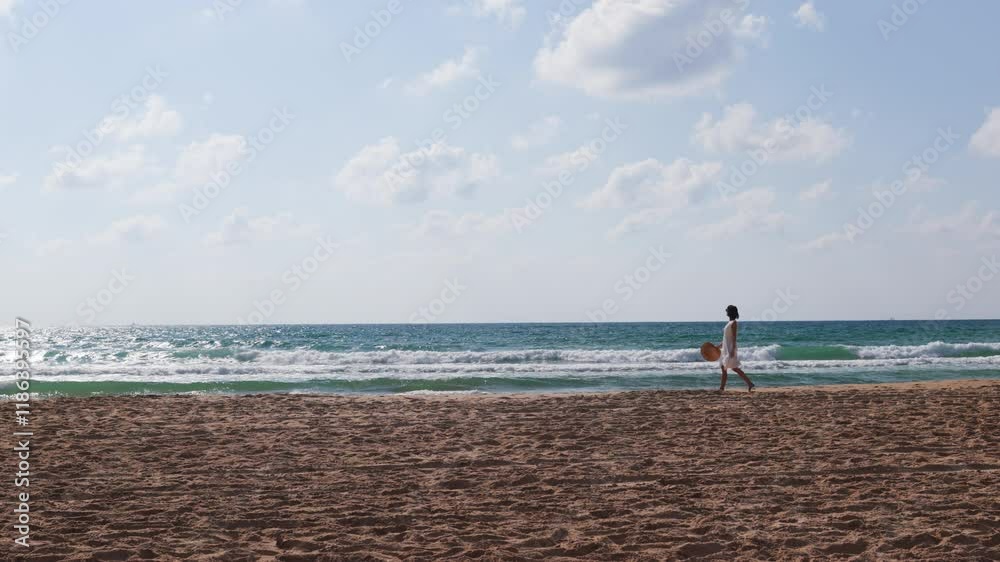 happy girl in a white dress walks along the beach and enjoys her vacation. A carefree girl walks along the beach on a sunny day. slender girl in a white dress on the beach. happy girl in a white dress walks along the beach and enjoys her vacation. A carefree girl walks along the beach on a sunny day. slender girl in a white dress on the beach.