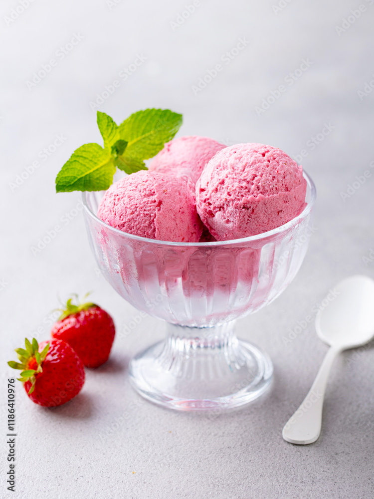 Strawberry Ice Cream in a glass bowl on grey background. Close up. Strawberry Ice Cream in a glass bowl on grey background. Close up.