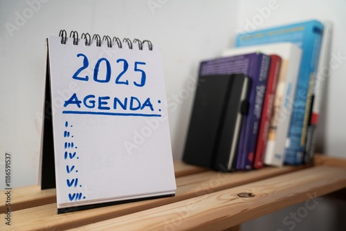 Obraz na płótnie
otwarty notes na półce z kartką na której zapisany jest tekst: 2025 Agenda oraz poniżej wykropkowane miejsce na tekst w salonie