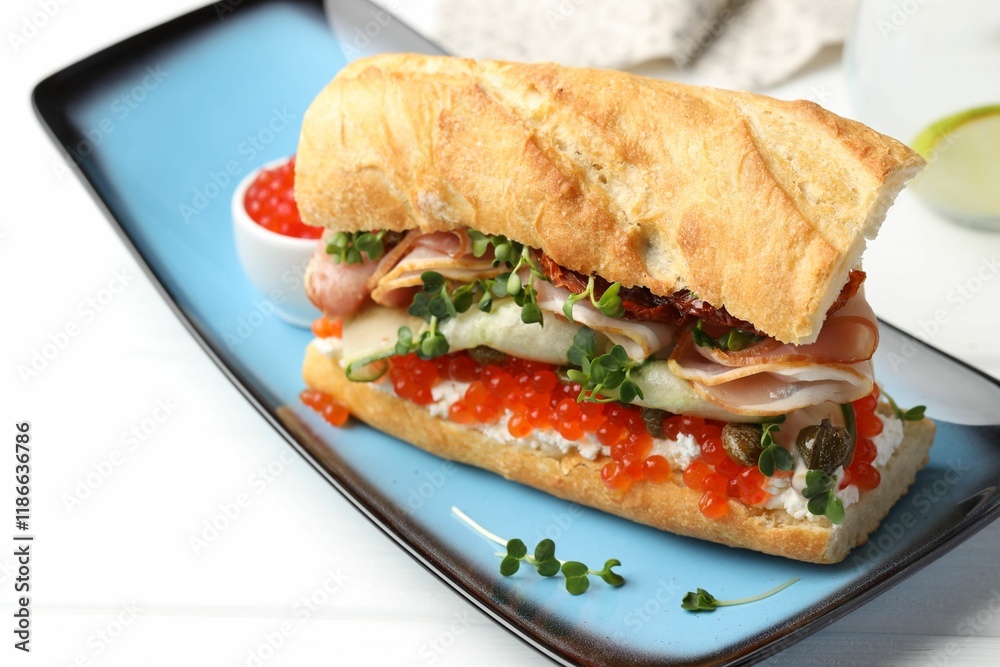 Obraz premium Delicious baguette sandwich with caviar, ham and capers on white wooden table, closeup