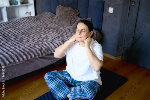 a senior woman performs somatic exercises, yoga at home