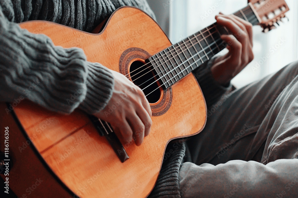 Fototapeta premium Musician enjoys playing guitar in cozy space