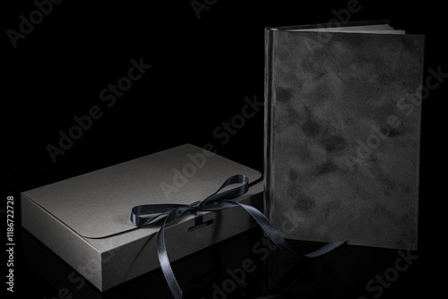 Best gift for men. Man gift concept. Grey notebook with Grey gift box on black background. Copy space. Valentine's day, wedding, birthday and special occasion gift concept. Copy space for text. photo