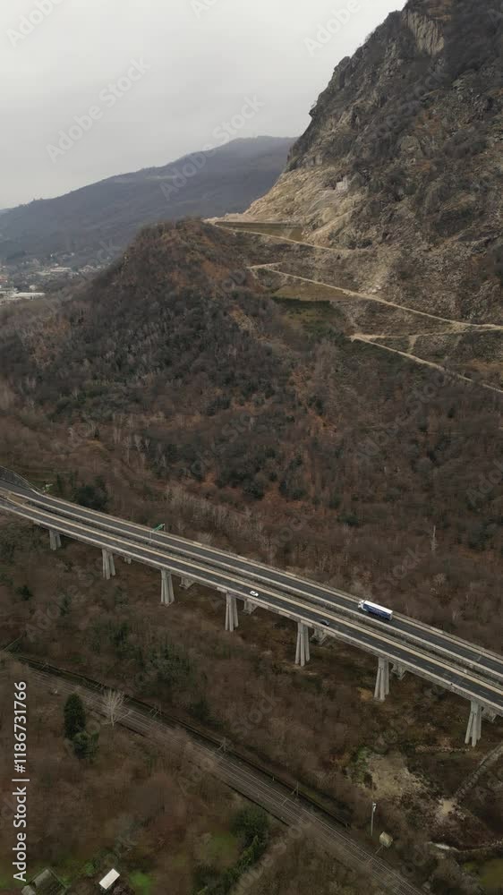 smooth drone video of Italian highway bridge in tunnel through the mountains with cars moving driving in a cloudy day smooth drone video of Italian highway bridge in tunnel through the mountains with cars moving driving in a cloudy day