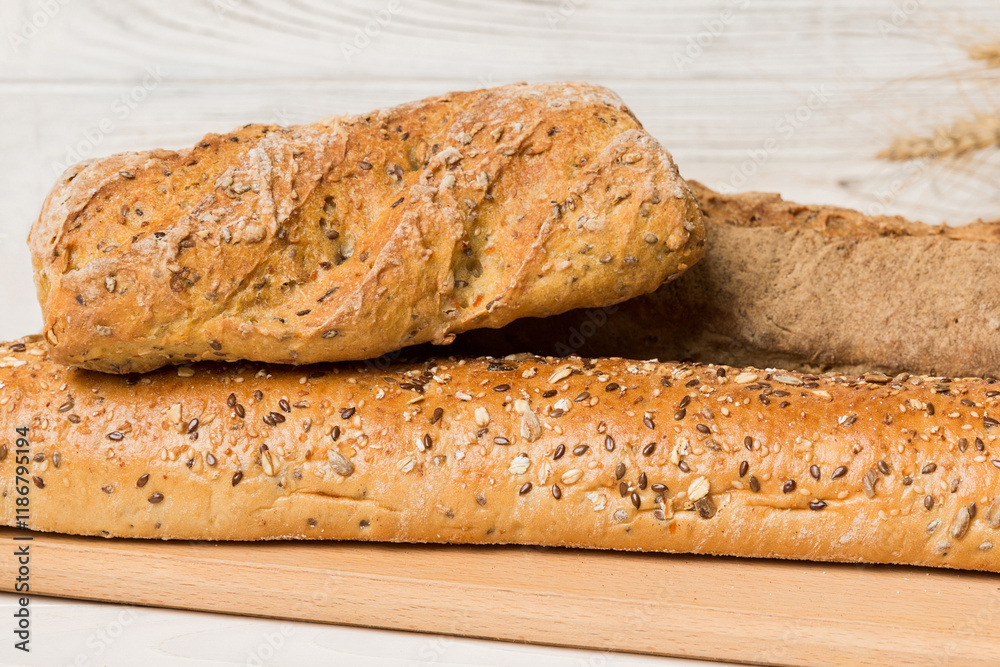 Freshly baked bread on cutting board against white wooden background. perspective view bread with copy space Freshly baked bread on cutting board against white wooden background. perspective view bread with copy space