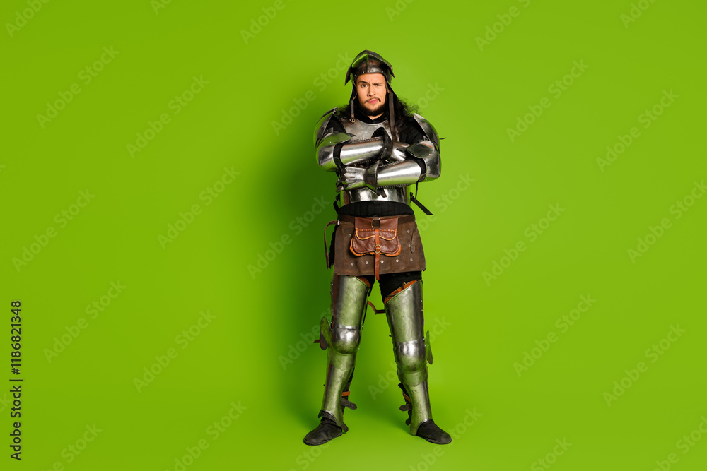 Man in medieval knight armor posing against green backdrop, blending historical costume with modern themes Man in medieval knight armor posing against green backdrop, blending historical costume with modern themes