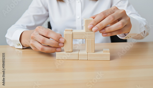 Businesswoman Building a Wooden Structure on a Desk