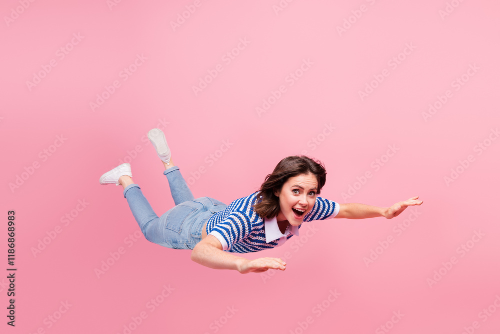 Φωτογραφία Young woman in casual fashion floating on pink background, arms outstretched in