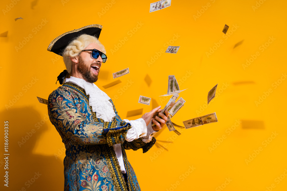 Fototapeta premium Young aristocrat in costume celebrates with money on yellow backdrop