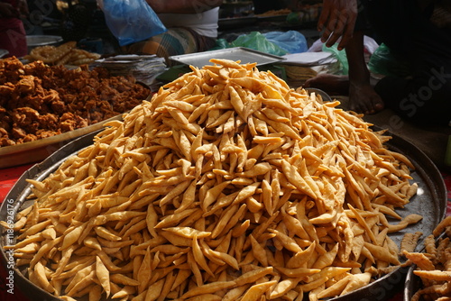 Flour made fried salted snacks called Nimki are on sale in a market, Traditional Asian snacks nimki are displayed on a local food stall, Closeup shot of salted Bengali Nimki selling as street food