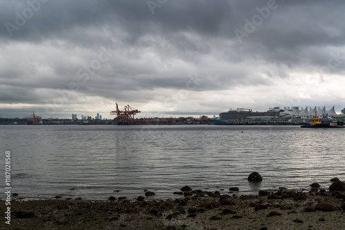 Fotografi Downtown Vancouver skyline across Coal Harbour as seen from Stanley Park on a cloudy day in British Columbia, Canada