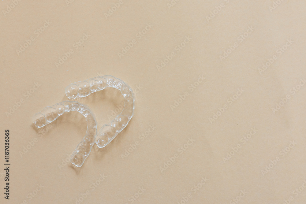 close up top view dental aligner retainer (invisible) on beige color background at dental clinic for beautiful teeth treatment course concept close up top view dental aligner retainer (invisible) on beige color background at dental clinic for beautiful teeth treatment course concept