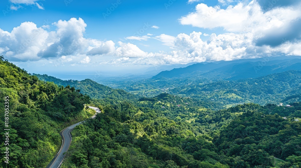 Aerial view of a winding road in a lush mountainous forest landscape under a bright blue sky ideal for text overlay and nature themes