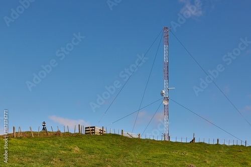 Transmitter tower on a green hill