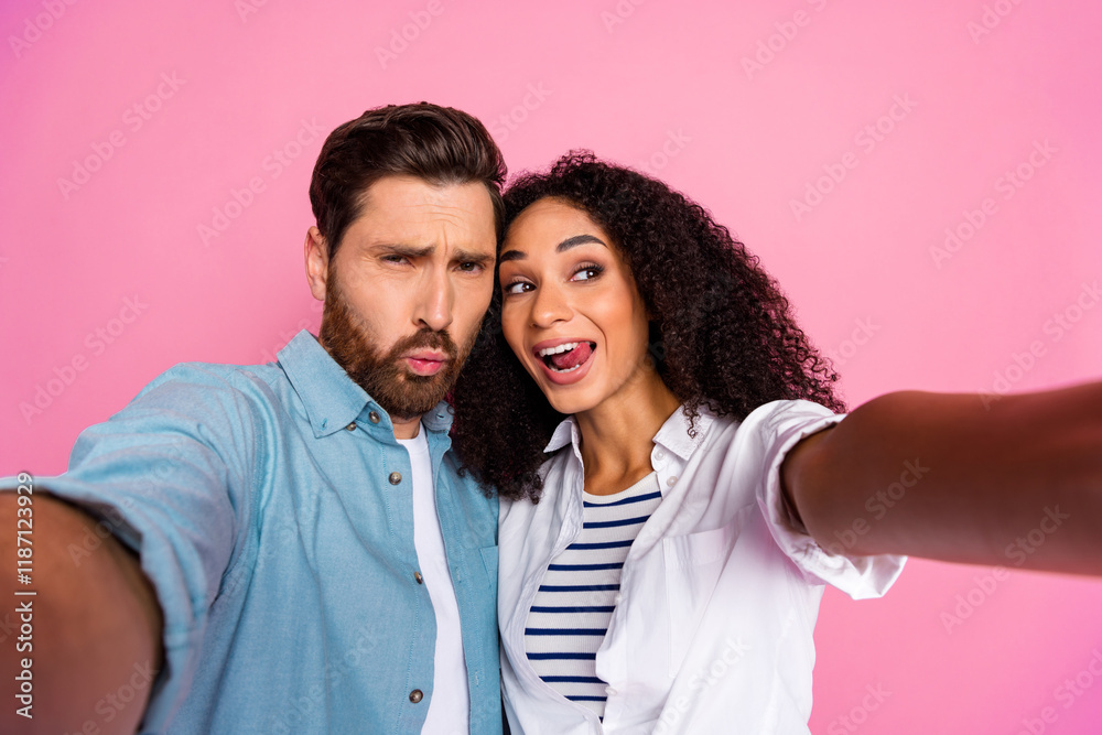 Young couple taking a selfie on a pink background showcasing joy and togetherness Young couple taking a selfie on a pink background showcasing joy and togetherness