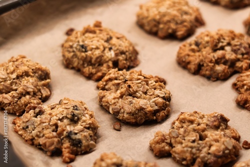The process of preparing homemade oatmeal cookies - baked cookies placed on a baking tray lined with baking paper