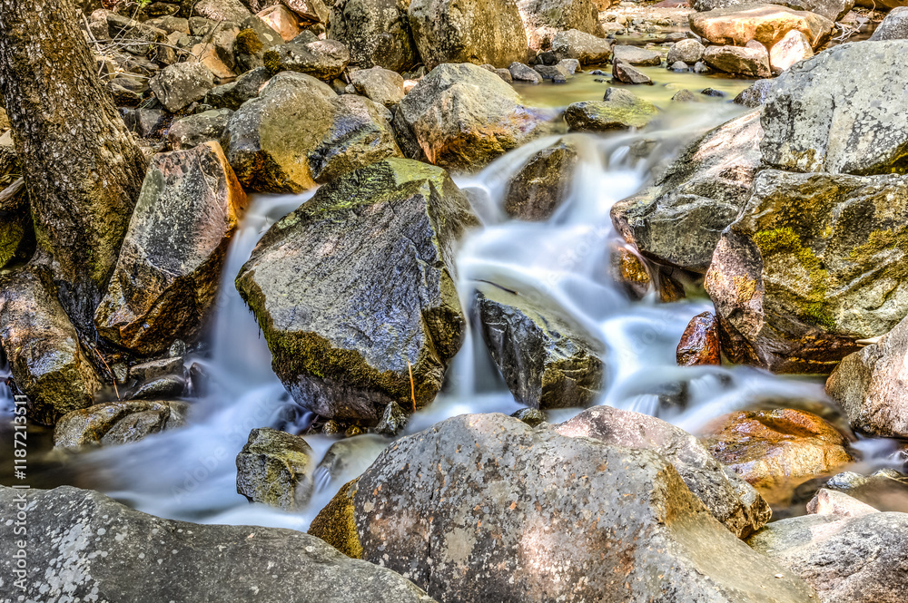 A stream of water flows over a rocky riverbed A stream of water flows over a rocky riverbed
