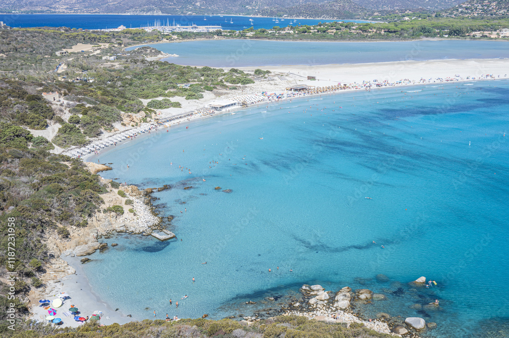 VIllasimius, Italy - 09-05-2024: Aerial view of the beautiful beach of Porto Giunco in Villasimius with white sand and crystal clear water with the Notteri pond in the background