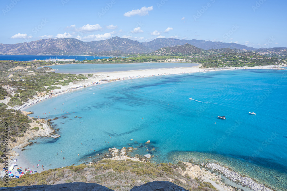 VIllasimius, Italy - 09-05-2024: Aerial view of the beautiful beach of Porto Giunco in Villasimius with white sand and crystal clear water with the Notteri pond in the background