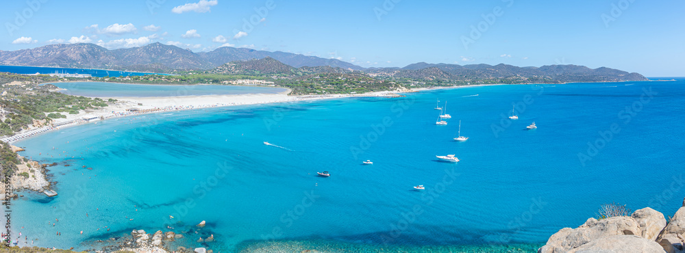 VIllasimius, Italy - 09-05-2024: Aerial view of the beautiful beach of Porto Giunco in Villasimius with white sand and crystal clear water with the Notteri pond in the background