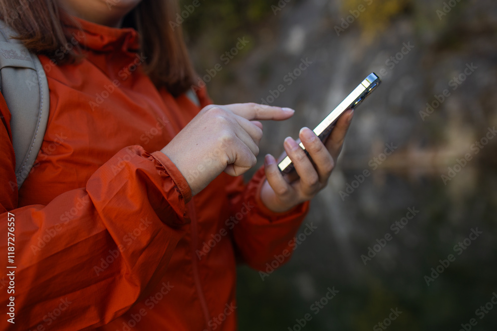 Traveler hiker woman holding smartphone in a hand and using GPS app with trekking in summer mountains outdoor. Point of view in first person. High quality photo