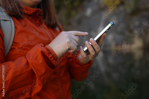 Obraz na płótnie Traveler hiker woman holding smartphone in a hand and using GPS app with trekking in summer mountains outdoor. Point of view in first person. High quality photo w salonie