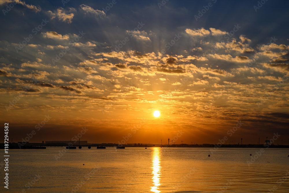 Doha Qatar: Sunrise over the water View from the old Doha port, creating a beautiful orange and pink sky Doha Qatar: Sunrise over the water View from the old Doha port, creating a beautiful orange and pink sky