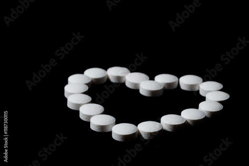 White round tablets are scattered on a black background.
