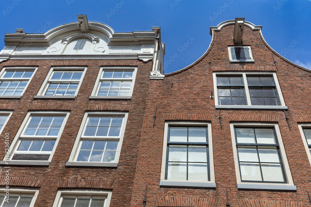 Dutch architecture. Pair of typical Dutch houses against a blue sky in Amsterdam. Netherlands. Horizontally. Dutch architecture. Pair of typical Dutch houses against a blue sky in Amsterdam. Netherlands. Horizontally.