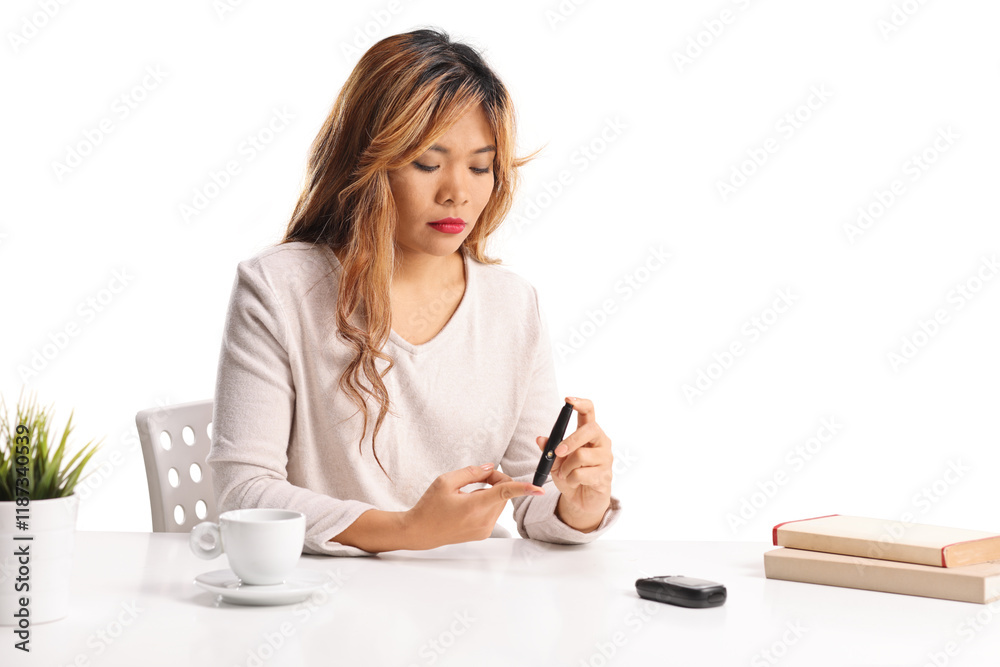 Young asian female checking blood sugar level Young asian female checking blood sugar level