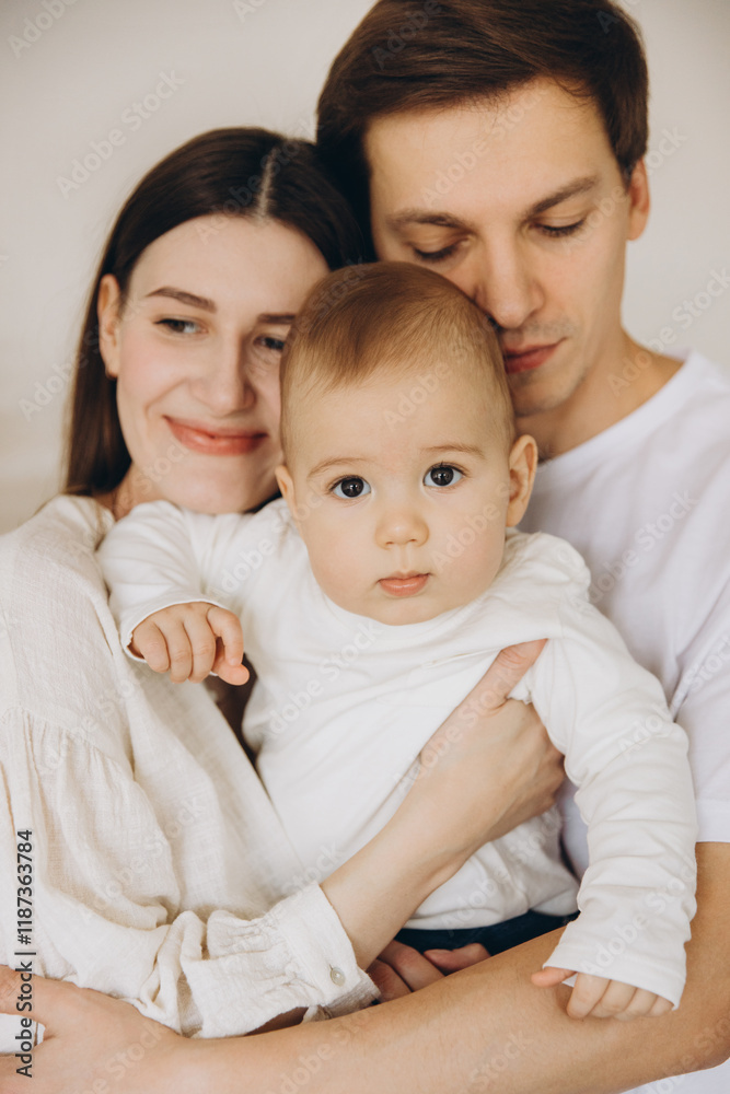 Young family embracing their baby with love and tenderness Young family embracing their baby with love and tenderness
