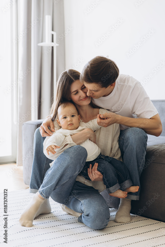 Happy family embracing and kissing their baby at home Happy family embracing and kissing their baby at home
