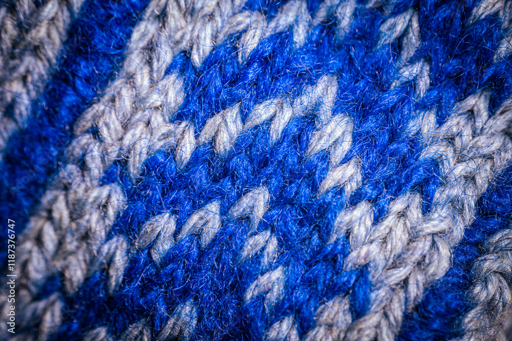 A detailed macro shot of blue and white knitted fabric, showcasing the soft texture and intricate weave of the yarn. The color contrast highlights the artistic pattern. A detailed macro shot of blue and white knitted fabric, showcasing the soft texture and intricate weave of the yarn. The color contrast highlights the artistic pattern.