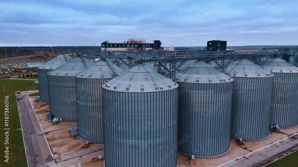 Approaching the cone tops of granary tanks standing in rows. Silo elevators at agricultural plant in the rural area. Approaching the cone tops of granary tanks standing in rows. Silo elevators at agricultural plant in the rural area.