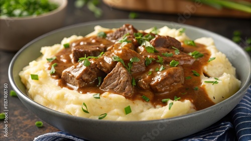 Beef stroganoff served on a bed of creamy mashed potatoes garnished with fresh herbs in a rustic setting