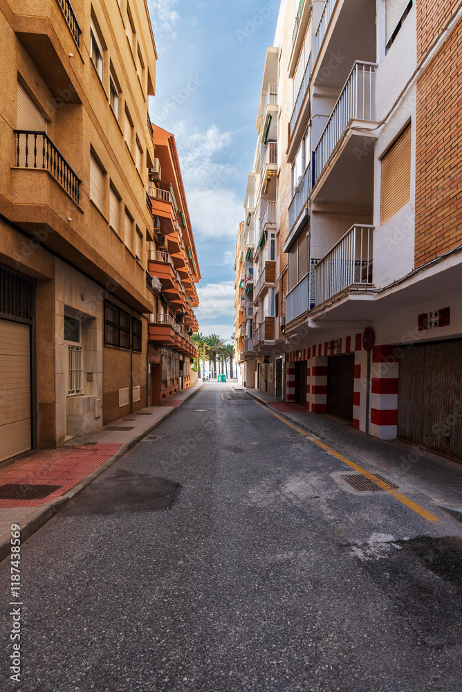 Narrow street with buildings very close to each other, blocking sunlight from entering for long periods, in the municipality of Torrenueva Costa, Granada, Andalusia. Narrow street with buildings very close to each other, blocking sunlight from entering for long periods, in the municipality of Torrenueva Costa, Granada, Andalusia.