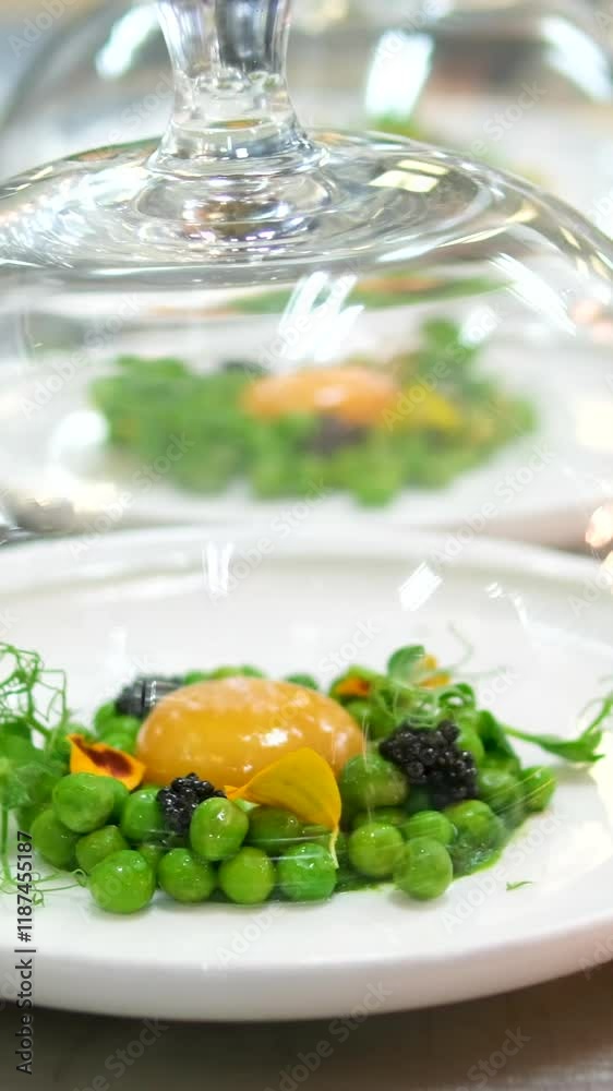 molecular cuisine. beautiful presentation of green peas with raw yolk on a plate with edible flowers and microgreens molecular cuisine. beautiful presentation of green peas with raw yolk on a plate with edible flowers and microgreens