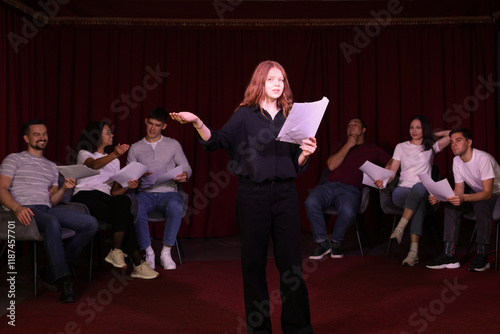 Professional actors reading their scripts during rehearsal in theatre