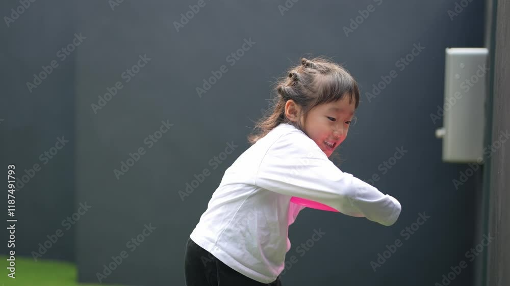 A Japanese parent and child, a 6-year-old woman and a man in his 20s, wearing simple white clothes, are happily playing with a flying disc at home. Slow motion video. A Japanese parent and child, a 6-year-old woman and a man in his 20s, wearing simple white clothes, are happily playing with a flying disc at home. Slow motion video.
