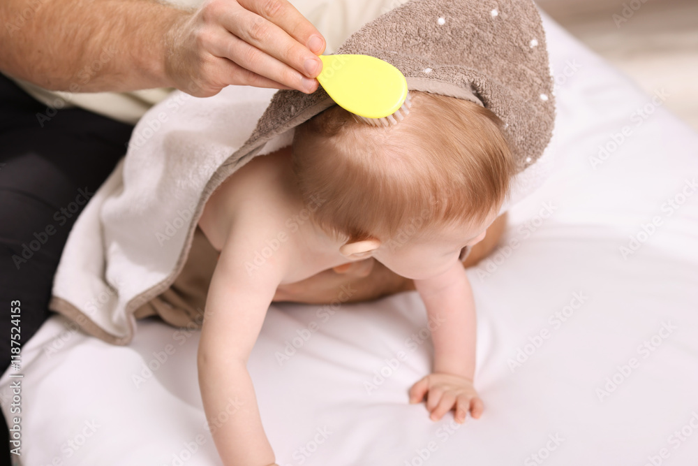 Man brushing hair of his little baby indoors, closeup