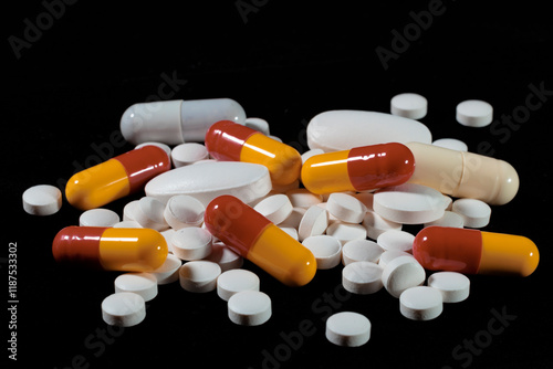 White round tablets are scattered on a black background.