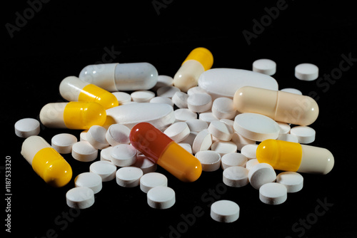 White round tablets are scattered on a black background.