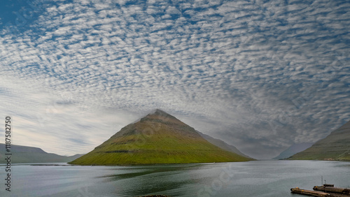 Majestic landscape of fjords, green mountains and the sea. Moody clouds envelop the scene. Located in the town of Klaksvík on the island of Borðoy, one of the northernmost islands in the Faroe Islands photo