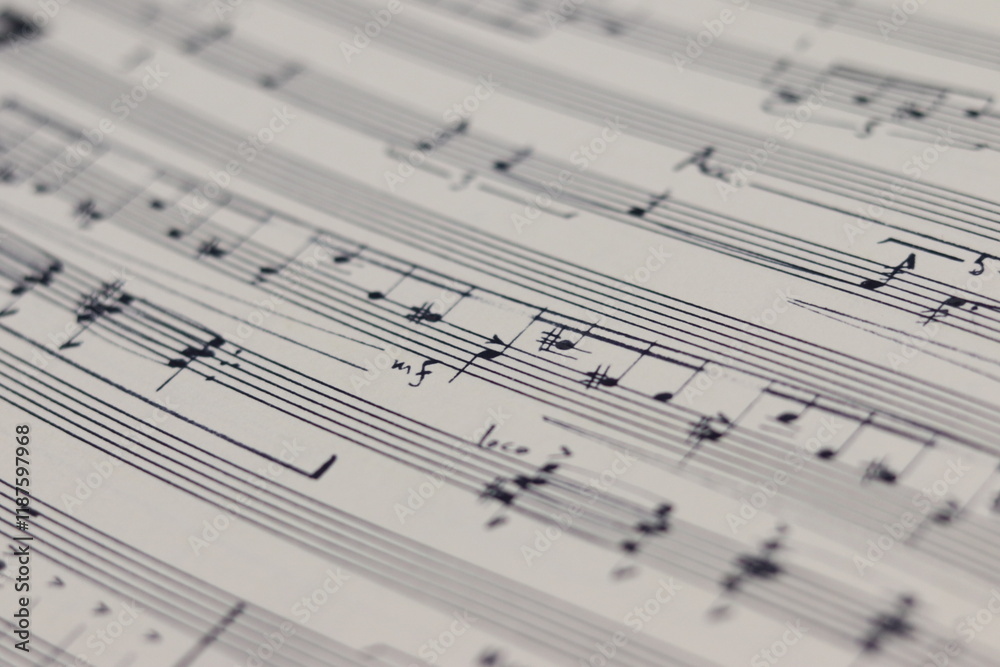 A white sheet with a musical partition. Musical notes on a sheet of music paper. Music notes as background with a close-up view. A white sheet with a musical partition. Musical notes on a sheet of music paper. Music notes as background with a close-up view.
