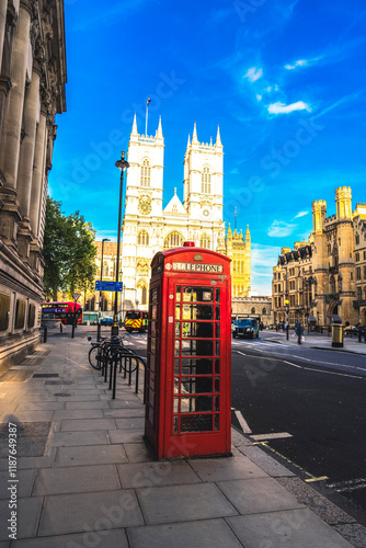 A classic red telephone booth on a London street, perfectly framed by the historic Westminster Abbey in the background. This image captures the essence of British heritage, blending traditional